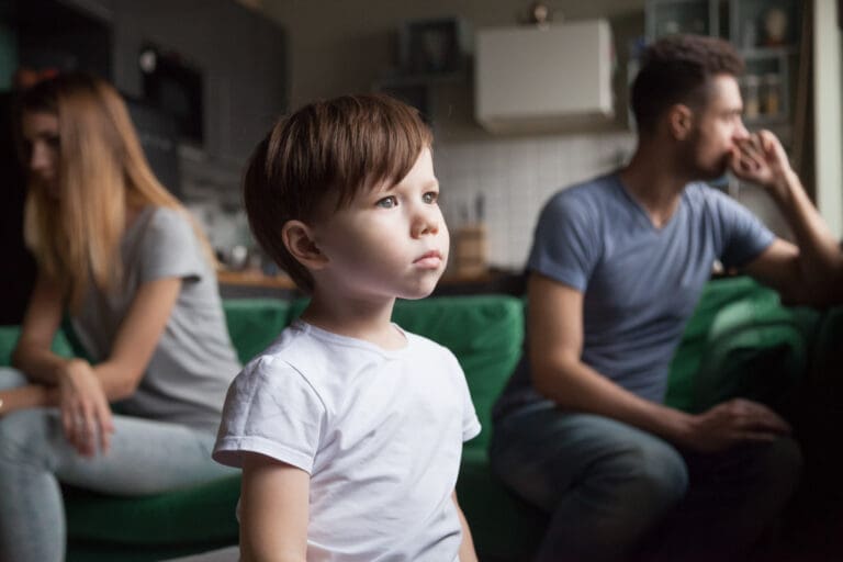 Sad child looking out window during parents’ argument