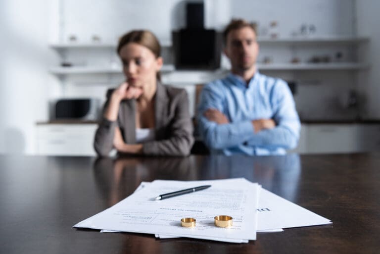 Couple sitting apart with divorce documents, showing legal separation